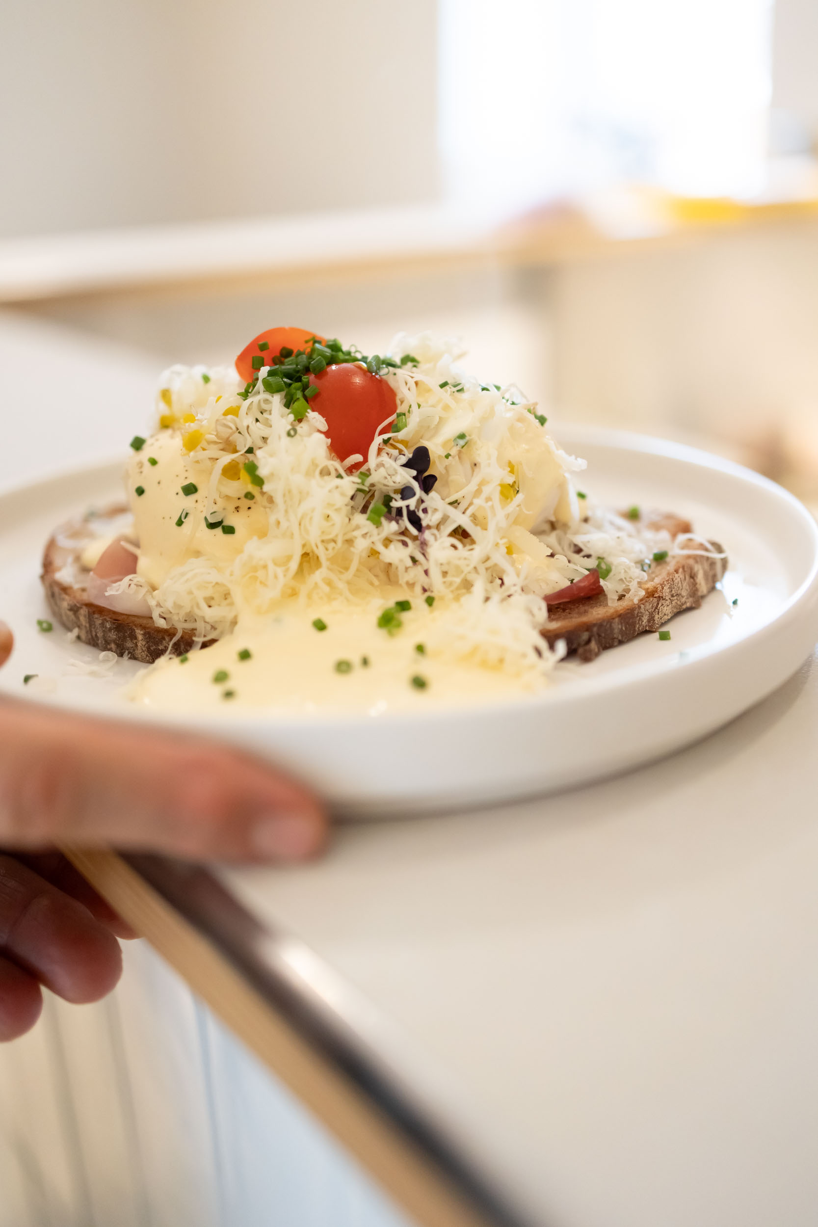 Eier Benedict mit Südtiroler Schinken, gehobeltem Parmesan, Sauce Hollandaise und Schnittlauch