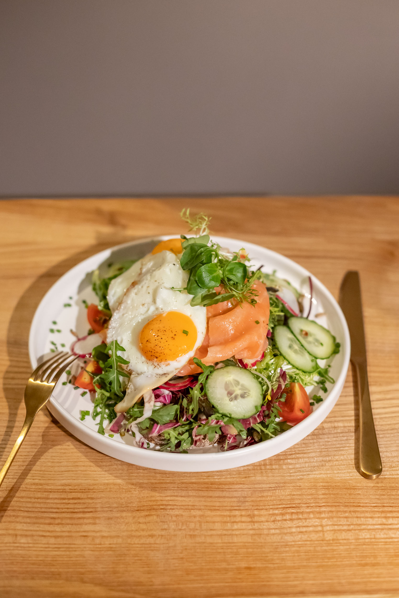 Krustenbrot Klassiker mit Frischkäse, frischer Avocado, Pflücksalat in Mango-Vinaigrette, Gurke, Kirschtomaten, gehobeltem Parmesan & 2 Spiegeleiern